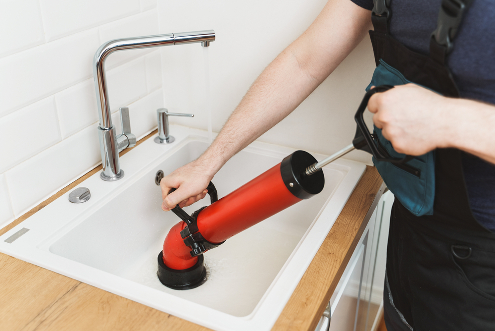 plombier débouge lavabo cuisine avec le nettoyeur à pompe à force professionnel Déboucha
